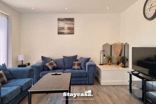 a living room with a blue couch and a table at Noor Garden Co-Living - Private Room Self-Cater in Manchester