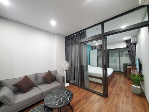 a living room with a couch and a bedroom at VNAHOMES APARTHOTEL in Hanoi