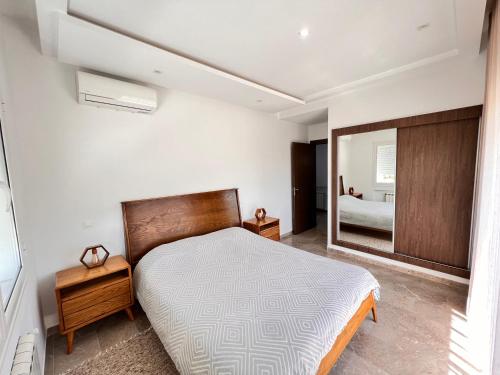 a bedroom with a large bed and a mirror at Abilia Suite - À Proximité de l'Aéroport - Confort et Élégance in La Soukra