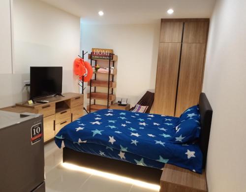 1 dormitorio con 1 cama y escritorio con TV en Infinity Pool at Kozi Square Homestay en Kuching