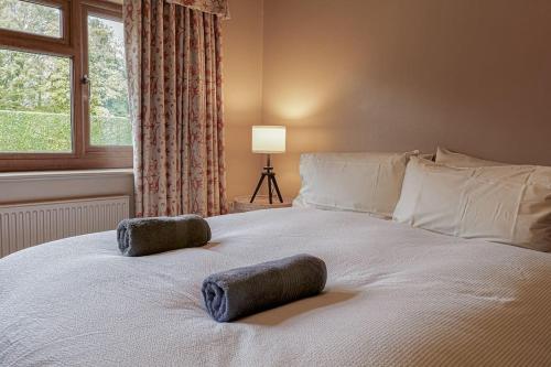 1 dormitorio con 1 cama con 2 almohadas en Charming 3BD Cotswolds Family Retreat, en Bourton on the Water