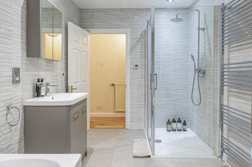 a bathroom with a shower and a sink at Charming 3BD Cotswolds Family Retreat in Bourton on the Water