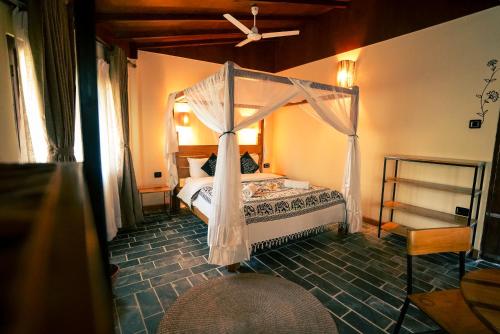 a bedroom with a bed with a canopy at Sapana Village Lodge in Sauraha