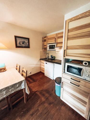une petite cuisine avec une table et un micro-ondes dans l'établissement Les Chardons Verts, Studio Pied de pistes, à La Salle Les Alpes