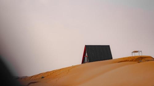 un edificio sentado en la cima de una duna de arena en Moon Light Camp, en Badīyah