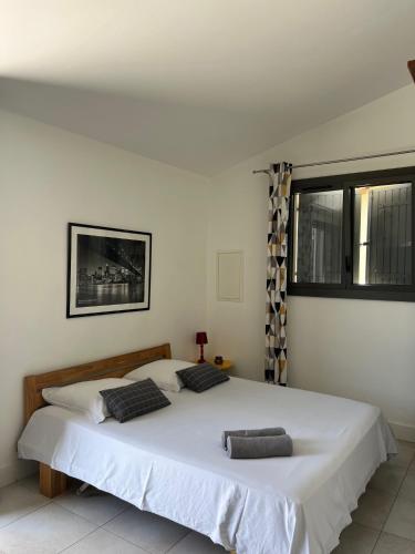 une chambre avec un lit blanc avec deux oreillers dessus dans l'établissement Gîte Crest, avec terrasse et piscine., à Crest