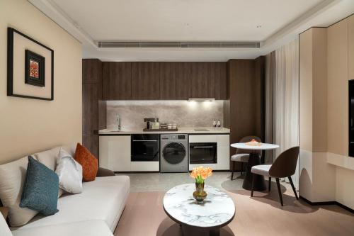 a living room with a couch and a kitchen at Yuexiu Hotel Guangzhou,Curio Collection by Hilton-Free shuttle between hotel and Exhibition Center during Canton Fair & Exhibitor Registration Counter in Guangzhou