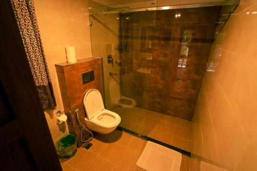 a small bathroom with a toilet and a shower at Sapana Village Lodge in Sauraha
