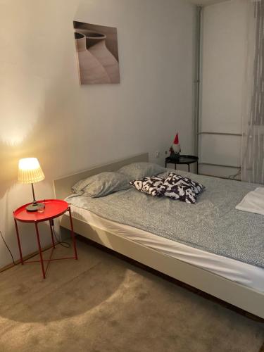 a bedroom with a bed with a red table at STUDIO APP STELLA Dnevni najam stana Jarun Zagreb in Zagreb