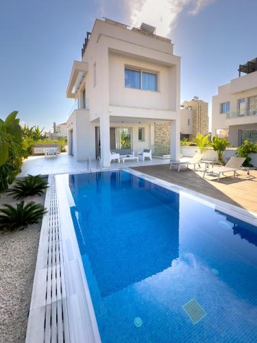 a villa with a swimming pool in front of a house at City Napa Seaview Villas - Villa 7 in Ayia Napa