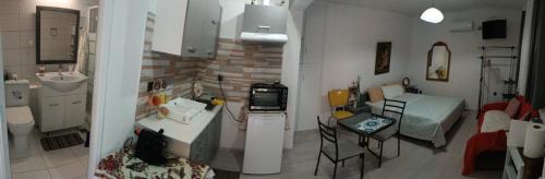 a kitchen with a sink and a kitchen with a counter at Παραθαλάσσιο στούντιο με κήπο in Saronida