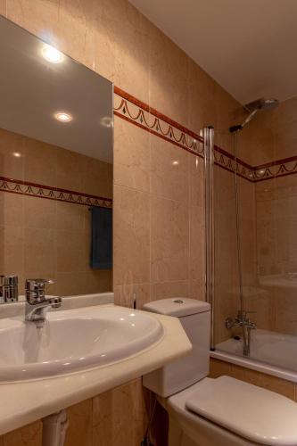 a bathroom with a sink and a toilet and a tub at AH Delux3Rooms Campus Milán VUT6519AS in Oviedo