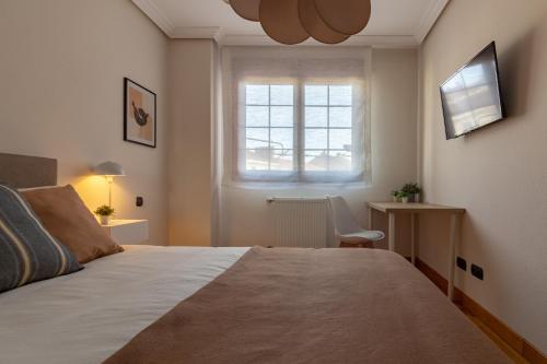 Un dormitorio con una cama y una ventana y un escritorio. en AH Delux3Rooms Campus Milán VUT6519AS, en Oviedo