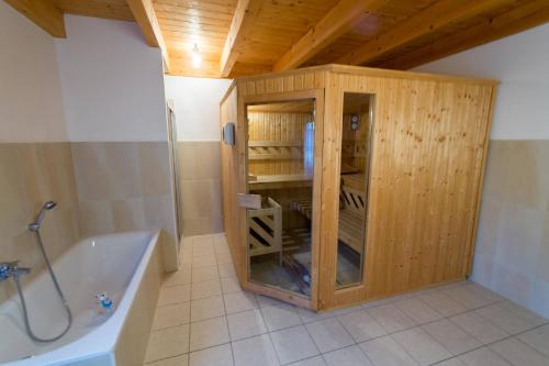 a bathroom with a wooden cabinet with a bath tub at Skiblickhaus in Russbach am Pass Gschütt