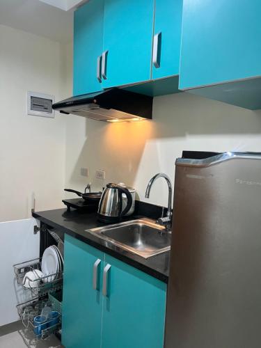 a kitchen with blue cabinets and a sink at The Persimmon Studios Tower 3 Unit 1153 located in MJ Cuenco Cebu City in Cebu City