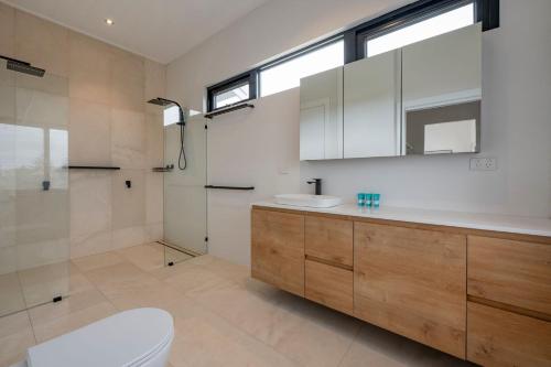 a bathroom with a toilet sink and a shower at Port Lane Townhouse in Geographe