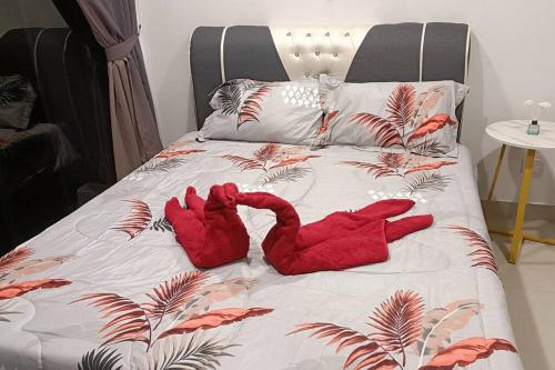 zwei rote ausgestopfte Tiere liegen auf einem Bett in der Unterkunft Cozy Flexus Signature Netflix, Pool and Privacy in Kuala Lumpur