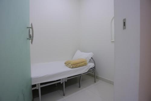 a hospital bed with a yellow towel on it at Hosta Serviced Apartments Al Malqa in Riyadh