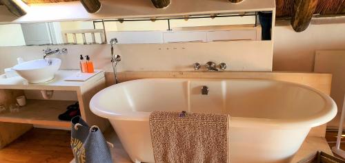a white bath tub in a bathroom with a sink at Nieuview Cottages 1 and 2 in Paternoster