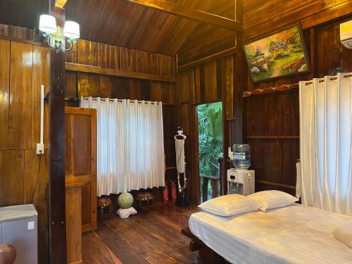 1 dormitorio con 2 camas y paredes de madera en Cat Tien River Lodge, en Cát Tiên