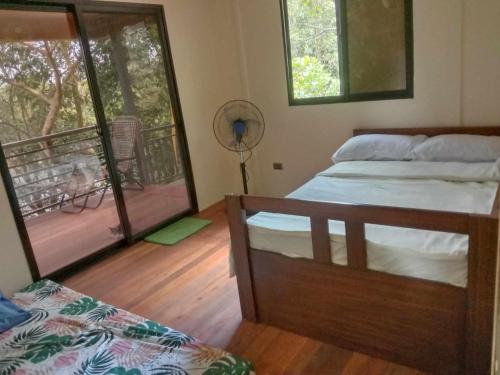 a bedroom with a bed and a balcony with a fan at Cozy Lake House Accommodation for 10 to 15 guests 