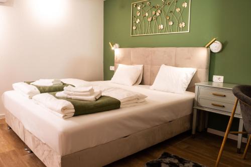 1 dormitorio con 1 cama grande y paredes verdes en Ljubljana Urban Apartments, en Liubliana