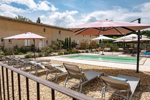 a group of chairs and umbrellas next to a pool at MAS PAPABIOU in Eygalières