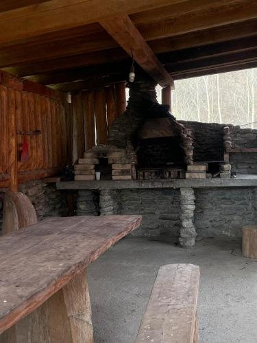 un banc en bois assis devant une cheminée en pierre dans l'établissement Intre Barse, à Zărneşti