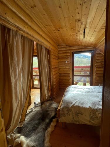 - une chambre avec un lit dans une cabane en rondins dans l'établissement Intre Barse, à Zărneşti