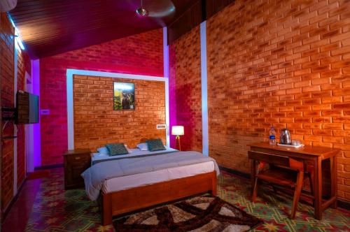 een slaapkamer met een bed en een bakstenen muur bij Elite Inn Cholai Lake View Resort in Taingapatam