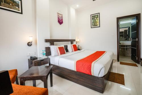 a bedroom with a bed and a desk and a chair at The Golden Sunrise Hotel in Nainital