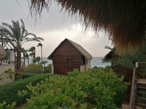 a small wooden house with the ocean in the background at Laguava Resort in Ar Rumaylah