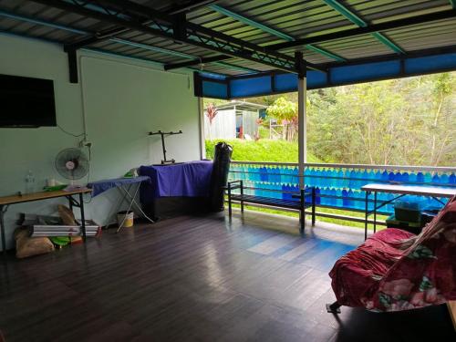 uma sala de estar com uma mesa e uma grande janela em Kou Pusan Home Kundasang em Kampong Kundassan