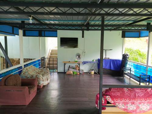 a room with beds and a child sitting on the floor at Kou Pusan Home Kundasang in Kundasang