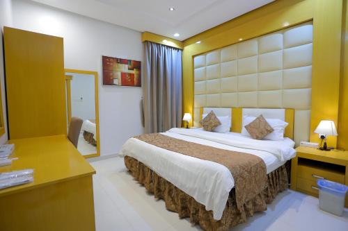 a hotel room with a large bed and a desk at Hosta Serviced Apartments Al Malqa in Riyadh