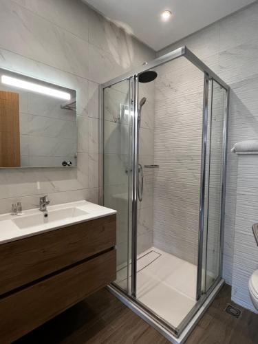 a bathroom with a glass shower and a sink at Dominium Residence in Agadir