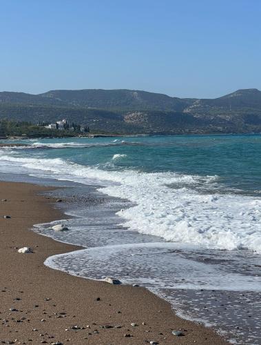 a sandy beach with waves crashing on the shore at Mountain View Apartment - Polis in Polis Chrysochous