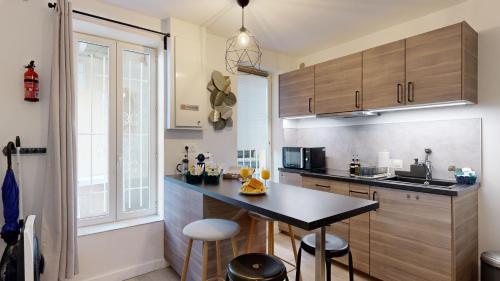 expat renting - L’Evasion - Saint Michel - Métro في تولوز: مطبخ مع طاولة وبعض الكراسي فيه