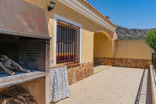 d'une terrasse avec une cheminée en briques et une fenêtre. dans l'établissement CASA RURAL C PUENTE DEL SEGURA, à Elche de la Sierra