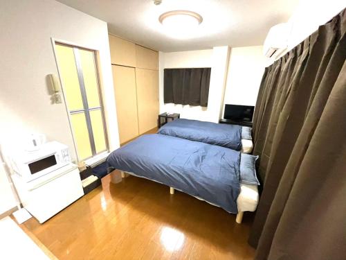 1 dormitorio con 1 cama y TV en Tokyo Stay Waseda, en Tokio