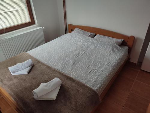 ein Schlafzimmer mit einem Bett mit zwei Handtüchern darauf in der Unterkunft Apartman Gradina Zlatibor in Zlatibor