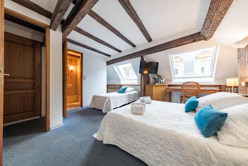 a bedroom with two beds with blue pillows at Hôtel du Centre in Metz
