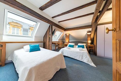 two beds in a room with a window at Hôtel du Centre in Metz