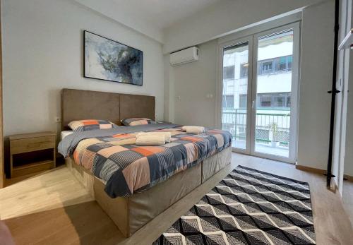 a bedroom with a bed and a large window at Stunning 2 BR Near Acropolis in Athens
