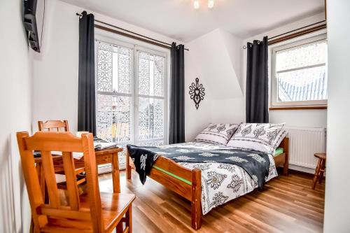ein Schlafzimmer mit Bett, Schreibtisch und Fenster in der Unterkunft U Ireny in Zakopane