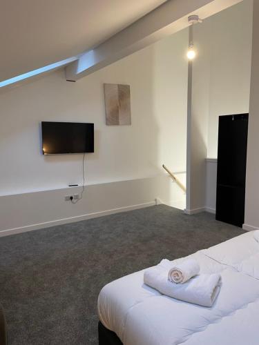 um quarto com uma cama e uma televisão de ecrã plano em Ascot House Apartments em Peterborough