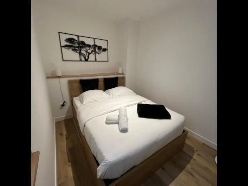 sypialnia z łóżkiem z białą pościelą i poduszkami w obiekcie Tonnelet Rouge - Appt au cœur de la ville w Strasburgu