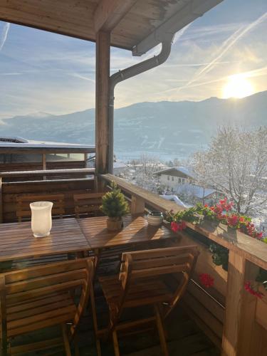 un tavolo in legno con sedie e un balcone con vista. di Apartments Karlhof a Innsbruck