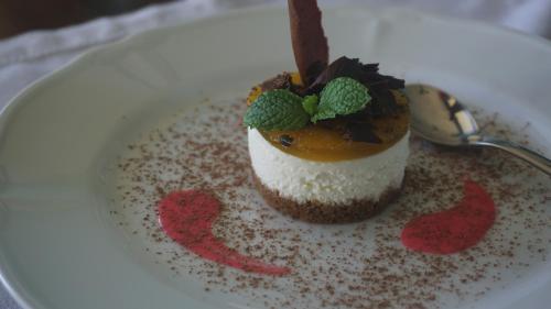 a dessert on a white plate with a spoon at Kandy Dendrobium House in Kandy