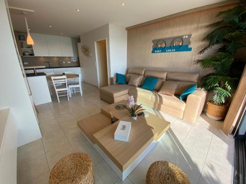 un salon avec un canapé et une table dans l'établissement RÉF 231 - PORT-LOUIS appartement type 2 pleine vue Petite Mer avec terrasse, parking et garage dans résidence récente, à Port-Louis